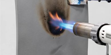 A heat gun burning a fabric creating a black burn mark.