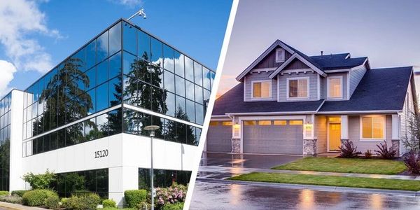 Modern office building and suburban house side by side.