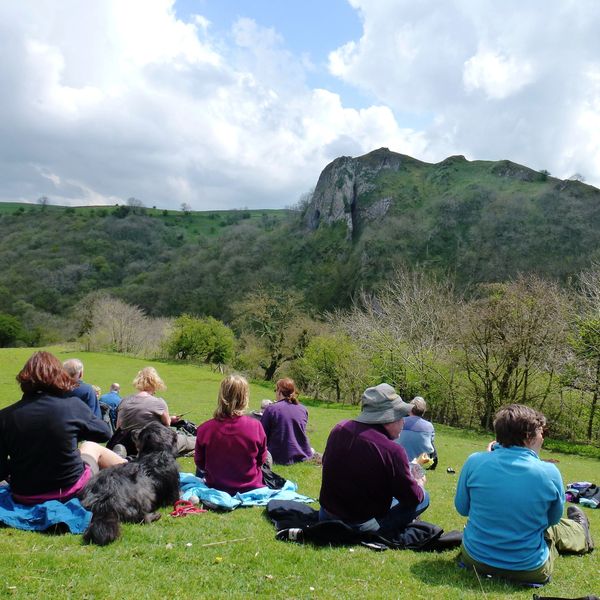 People looking across the Manifold valley to Thor's Cave, whilst sat and enjoying their lunch break.