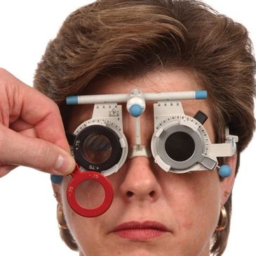 Person undergoing an eye test with a phoropter.