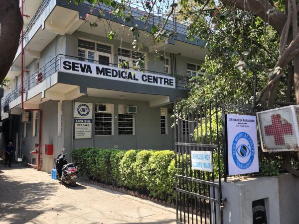 Exterior view of Seva Medical Centre with signage and greenery.