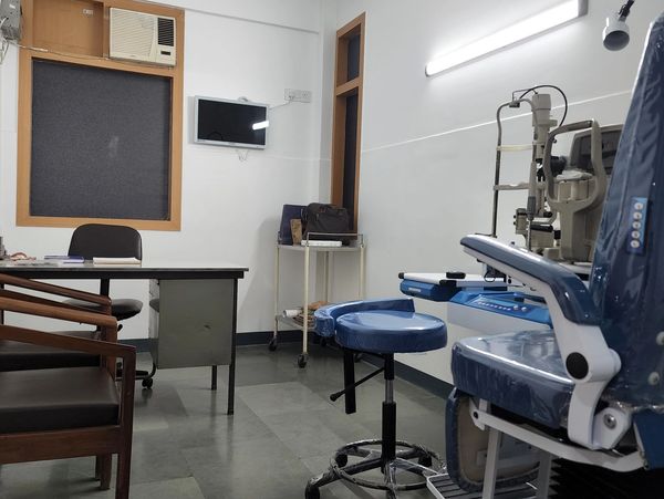 A clean medical or eye clinic room with equipment and seating.