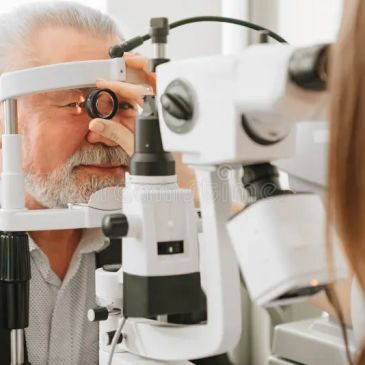 Senior man receiving an eye exam with slit lamp.