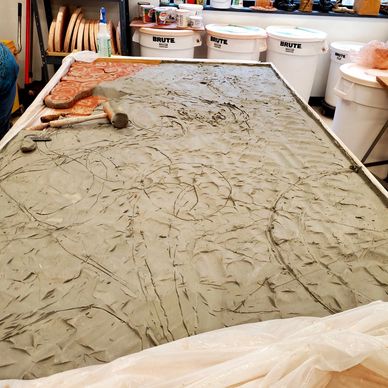 Pictured is a slab of clay in preparation for modeling the ceramic relief mural Lady Clove.
