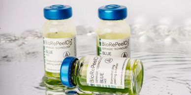 Three small vials of BioRePeelCl3 blue solution on a reflective surface.