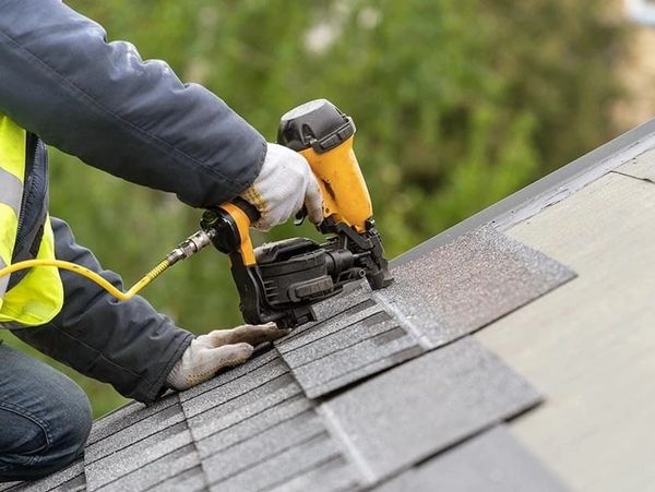 Roofer nailing shingle