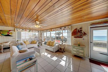 Open-concept living room and kitchen with Gulf views through the windows at Lotts of Sun beach house