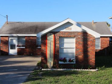 Exterior of the retro 1960 beach front cottage from the beach side
