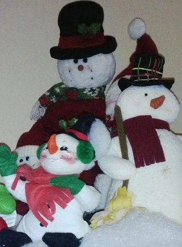Three festive snowman decorations wearing hats and scarves.
