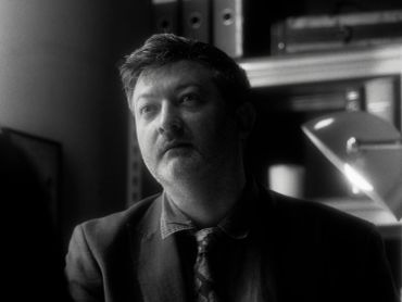 Black-and-white portrait of a man in a suit looking thoughtful.