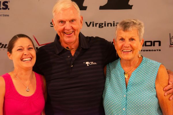 Three smiling adults posing together at an event.