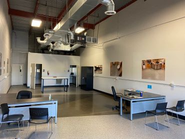 Spacious, industrial-style office with desks and chairs.