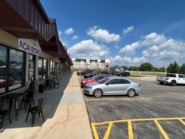 Outdoor view of a parking lot with a cafe named Acai Bowls.