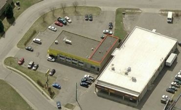 Aerial view of a commercial area with parking lots and two buildings.