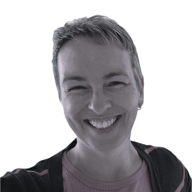 Smiling person with short hair and a striped sweater.