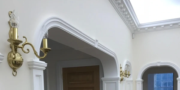 Elegant white walls with gold sconces and detailed molding.