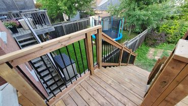 Second story pressure treated deck with aluminum spindles and wooden railings. Located in Clarington