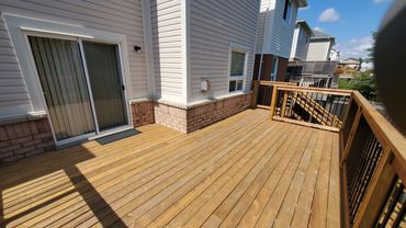 pressure treated deck with wooden railings and aluminum spindles. located in Bowmanville, Ontario.