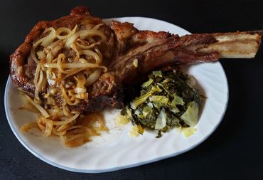 Tomahawk Steak Smothered with Onions with a side of Cabbage and Kale