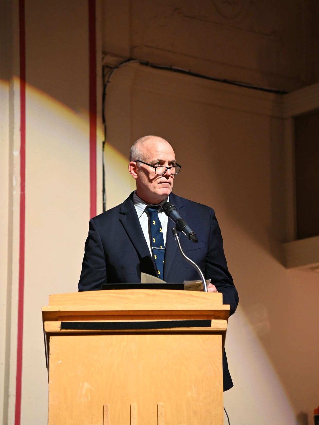 Man in suit speaking at a podium.