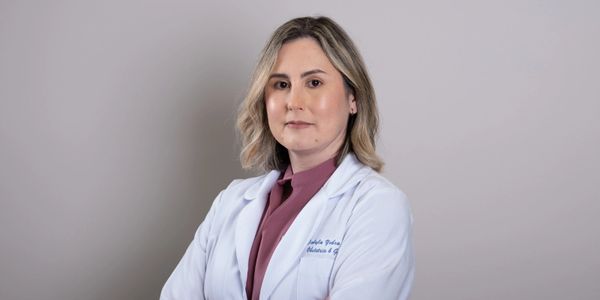 Professional woman doctor in white coat with folded arms.