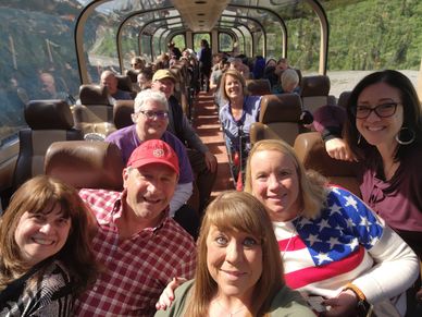Group of smiling people on a scenic train ride.