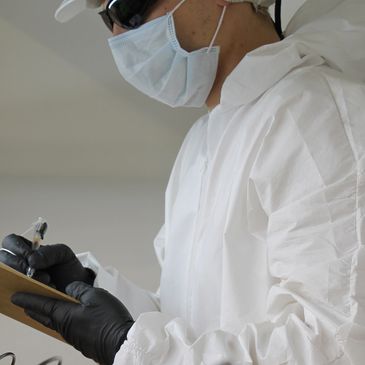 Person in protective gear writing on clipboard.
