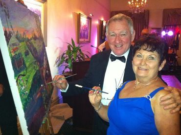 Wedding guests add to a wedding painting.
