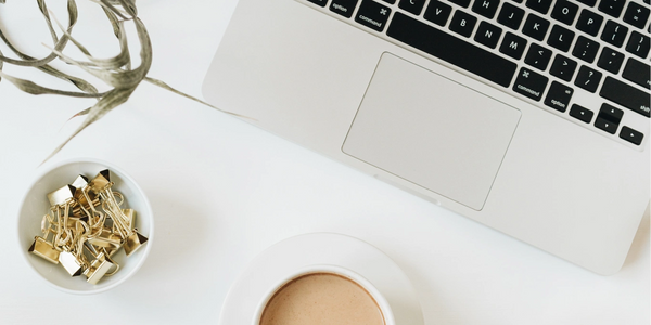 computer and coffee cup on a desk