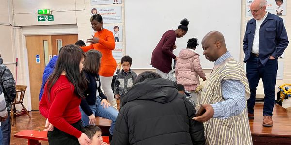 A diverse group of people interacting in a community event indoors.