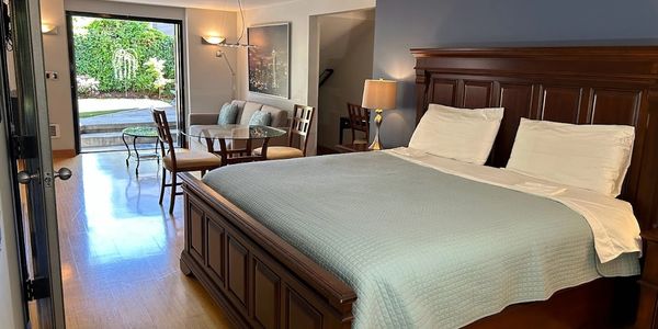 Cozy bedroom with wooden bed and garden view.