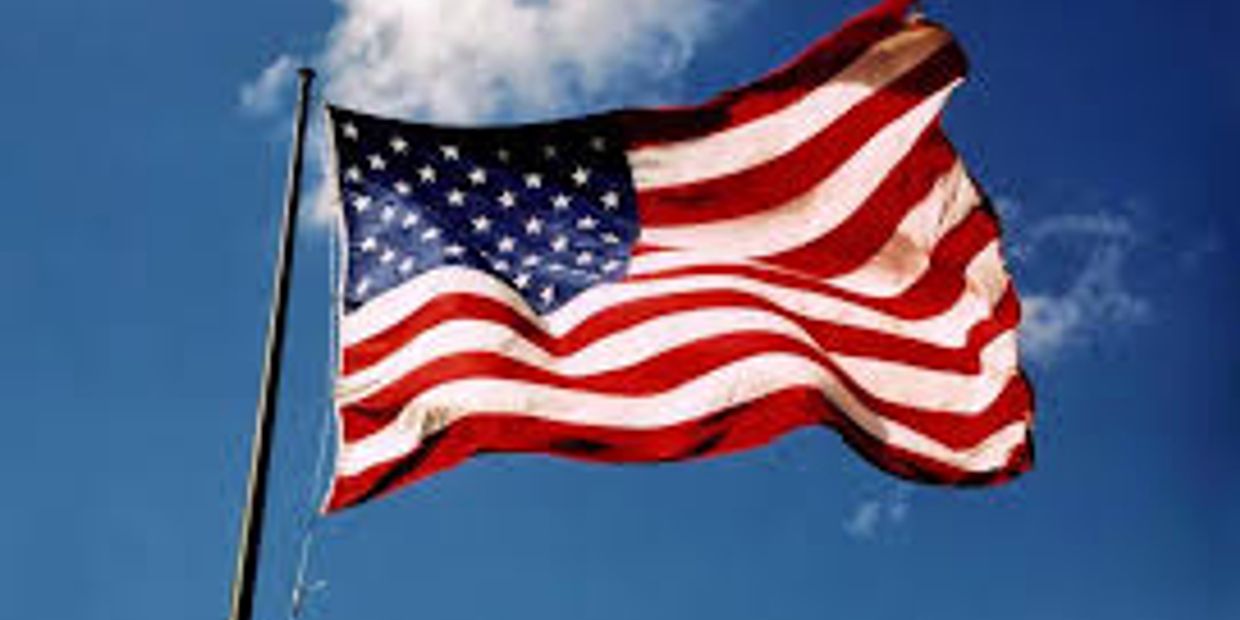 American flag waving against blue sky.