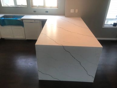 Pental Quartz Arezzo Honed with Farm Sink and Custom miter waterfall edge to floor.