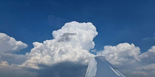 Wolkenhimmel über einem Flugzeugflügel.
