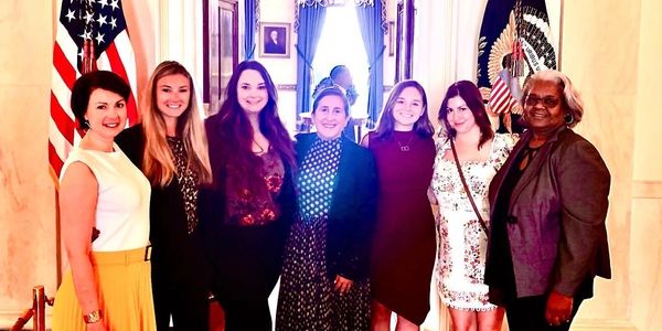 Members of the Boardroom pose for a photo in front of The Red Room while visiting The White House.