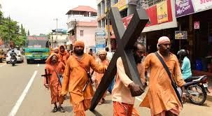 Carrying a large cross but wearing Hindu monks attire. WHY? Carrying a large cross but wearing Hindu monks attire. WHY?