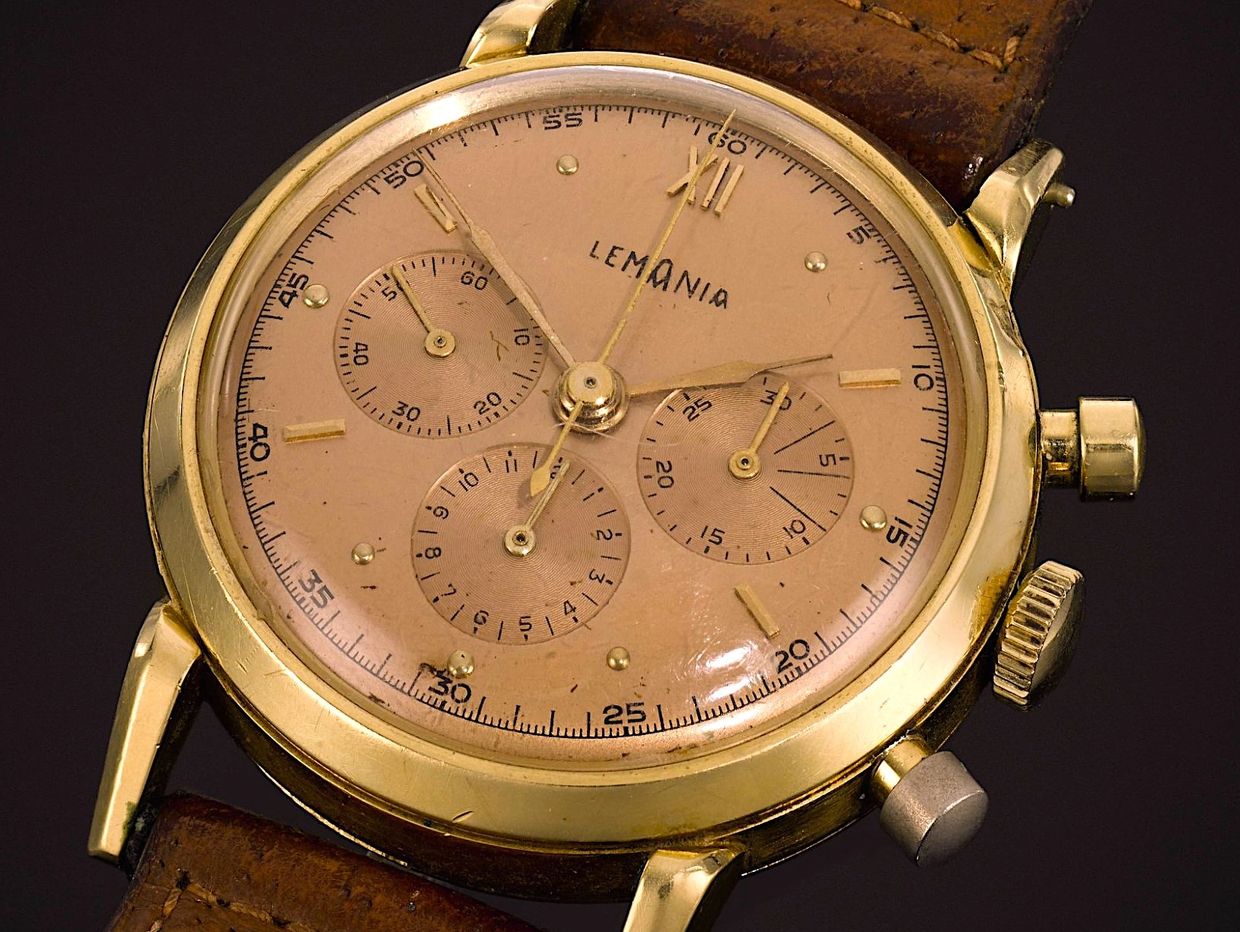 Vintage Lemania wristwatch with a gold case and leather strap.