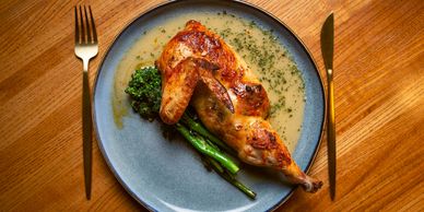 Grilled chicken with asparagus and green sauce on a blue plate.