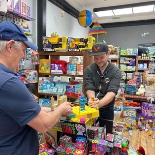 Father and son playing rock'em sock'em Robots at Nanni and Deeda's Toy store in Santa Paula CA.