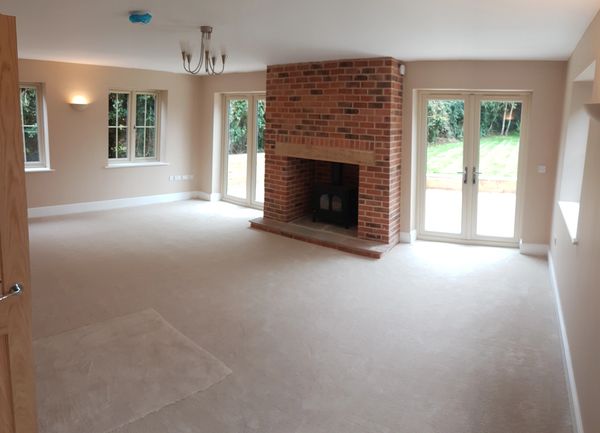 Spacious living room with brick fireplace and large windows.