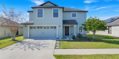 Modern two-story house with a clean driveway and green lawn.