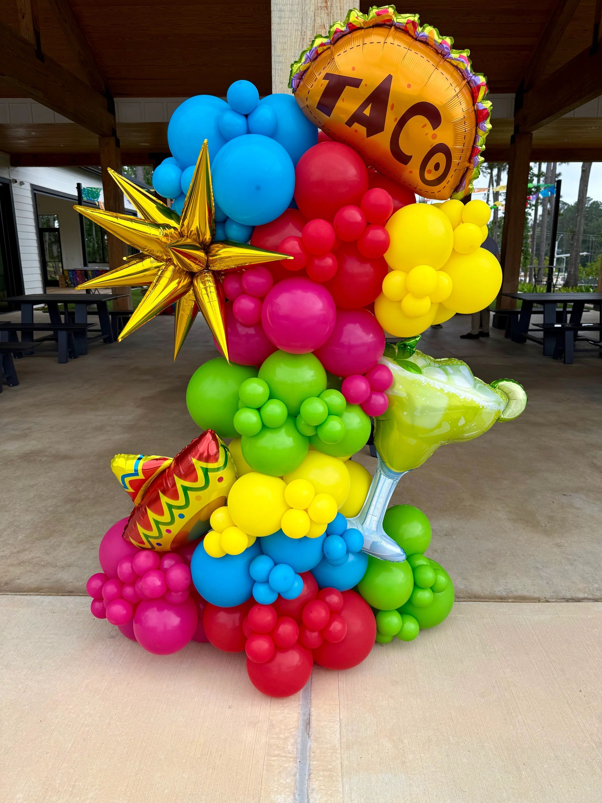 Colorful balloon arrangement with taco, star, and drink shapes.