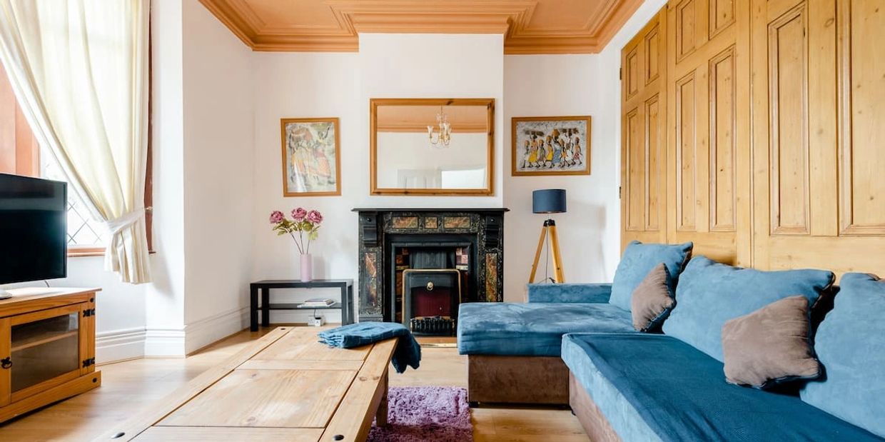 A living room with a couch, a fireplace, and a TV set