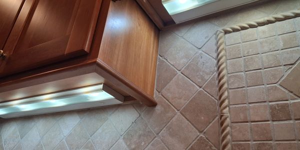 Wooden cabinets with under-cabinet lighting and tiled floor with rope border.