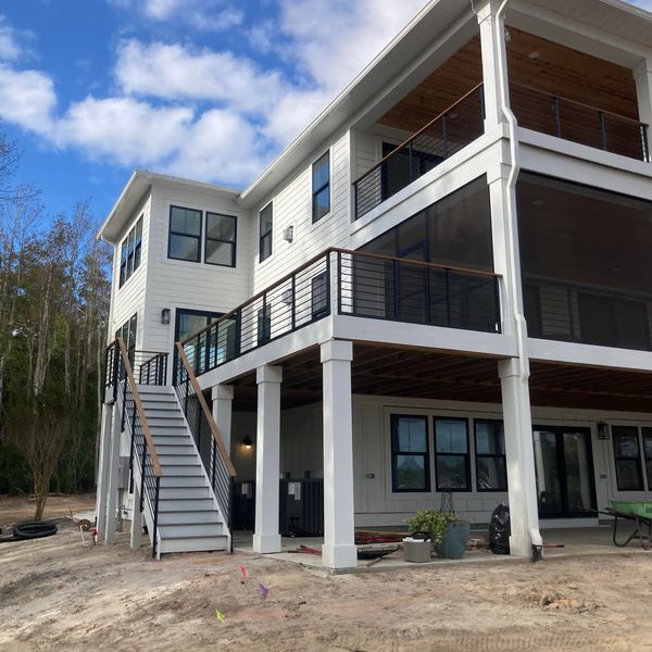 Deck and stair rails with custom wood rail cap on second and third floor landings