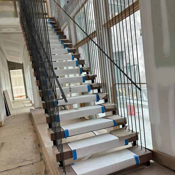 Monobeam stair with custom vertical rails and grab rail