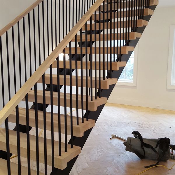 Monobeam stair with vertical rail pickets and custom wood rail cap