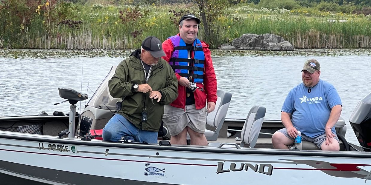 Three men enjoying a fishing trip on a boat in a serene lake.