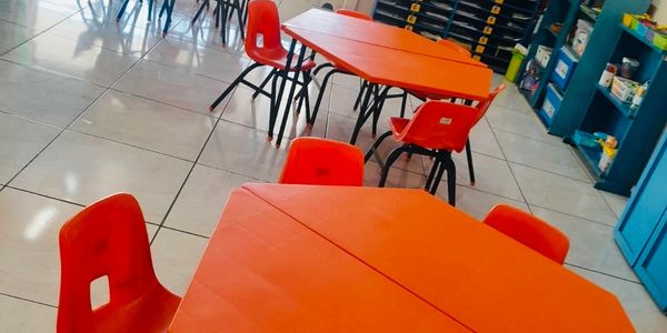 Mesas y sillas rojas en un salón.