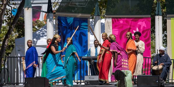 Colorful traditional Sudanese dance performance with wooden swords at Yerba Buena Gardens African Festival.